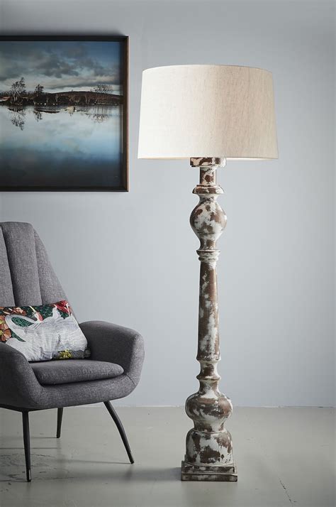 This ames drum floor lamp with storage shelf features two shelves with a distressed iron finish and a durable white ames shade; Rook Large Turned Wood Pillar Floor Lamp Distressed White ...
