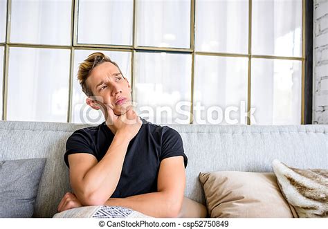 A Young Pensive Man On The Sofa In A Loft Style Apartment A Young