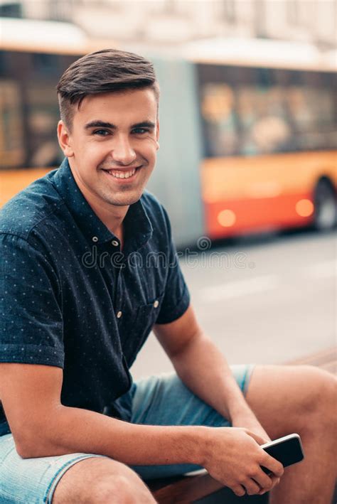 Smiling Young Man Sitting On A Bench In The City Stock Image Image Of