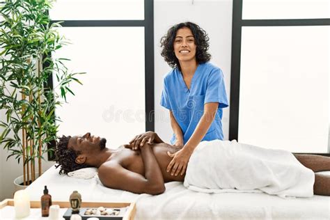 Young Physiotherapist Woman Giving Abdominal Massage To African