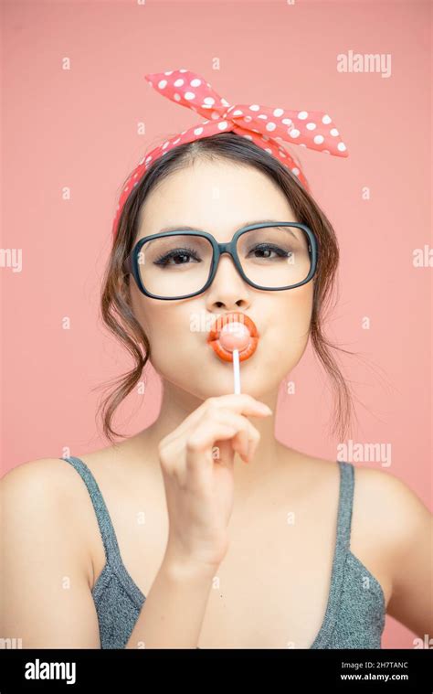 Woman Sucking Lollipop In Lips On Pink Background Isolated Stock Photo