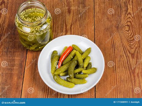 Pickled Gherkins On Saucer And In Jar On Rustic Table Stock Image