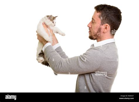 Profile View Of Young Handsome Caucasian Man Holding Cat Stock Photo