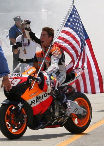 A Man Riding On The Back Of A Motorcycle With An American Flag In Front
