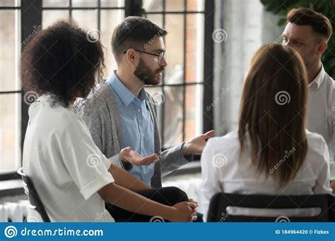 Serious Man Wearing Glasses Sharing Problems At Group Therapy Session