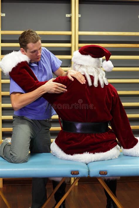 Terapista Maschio Che Massaggia Santa Claus Sovraccarica Immagine Stock