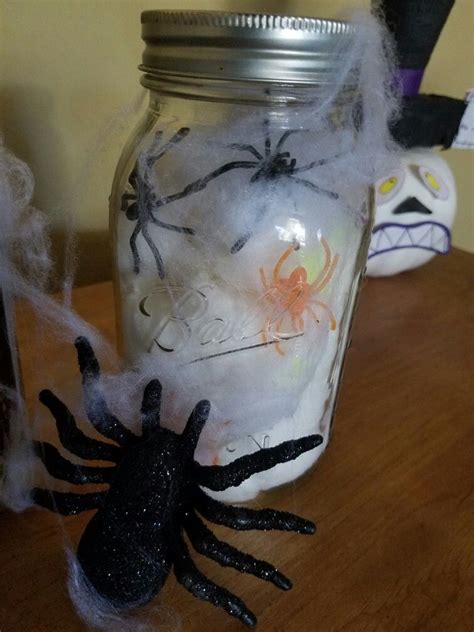 A Mason Jar Filled With Halloween Decorations On Top Of A Wooden Table