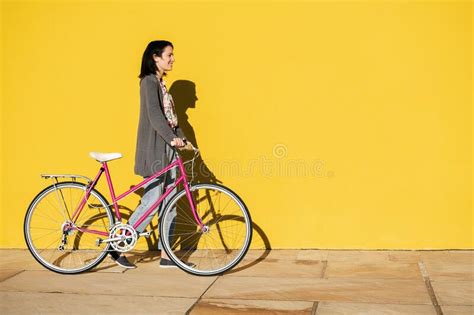 Girl With A Bike Walking In Front Of Yellow Wall Stock Photo Image Of