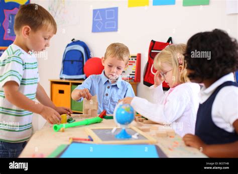 Four Kids Playing In Preschool Classroom Stock Photo