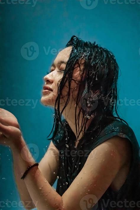 Portrait Of Indonesian Woman Taking A Bath In The Shower While Wearing A Black Dress 19047499