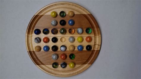 A Wooden Board With Many Different Colored Marbles On It And A White