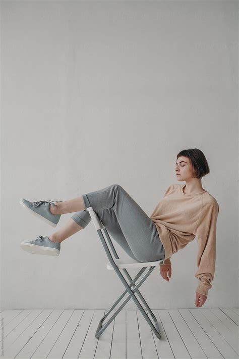 Stylish Woman Sitting On The White Chair By Stocksy Contributor Sergey Filimonov Sitting