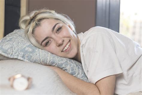 A Beautiful Happy Content Woman Lying In Bed Smiling At Camera Stock