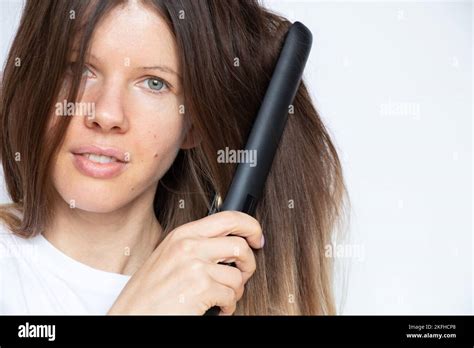 The Girl Straightens Her Hair With Straightening Tongs On A White Background Hair Care Curlers