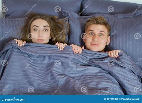 A Guy And A Girl Hide Their Faces Behind A Blanket A Happy Couple In