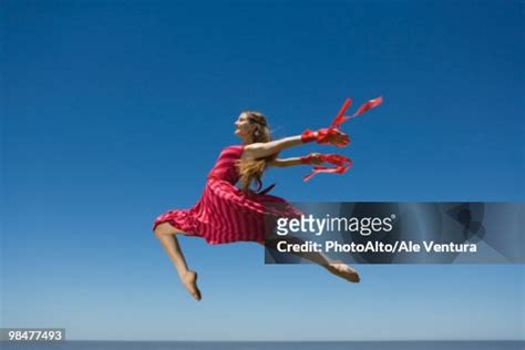 Young Woman Leaping Midair High Res Stock Photo Getty Images