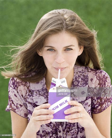 Young Woman Drinking Milk Through Straw Portrait High Res Stock Photo