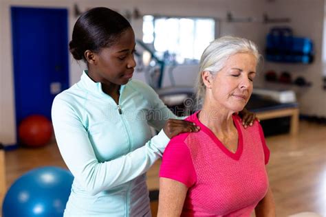 Female Physiotherapist Giving Back Massage To Active Senior Woman In