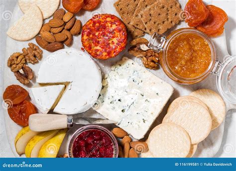 Assortment Of Gourmet Cheeses And Snacks On Board Top View Stock Image