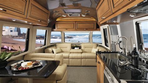 The Interior Of An Rv With Couches Kitchen And Living Room Area In It