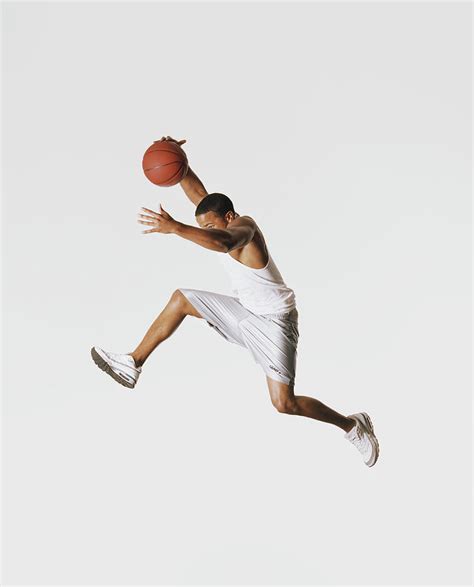Young Man Holding Basketball In Mid Air By Stephen Stickler