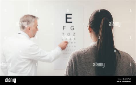 Woman Reading The Eye Chart The Ophthalmologist Is Pointing At One