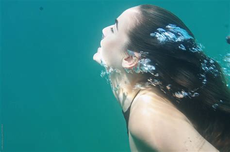 Brunette Woman Swimming Forward With Bubbles By Stocksy Contributor Rolfo Stocksy