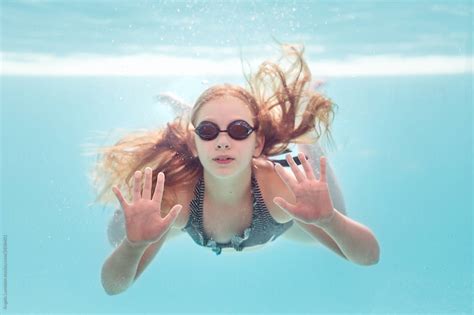 Girl Underwater Swimming Pressing Up Against A Glass Pool Wall By Stocksy Contributor Angela