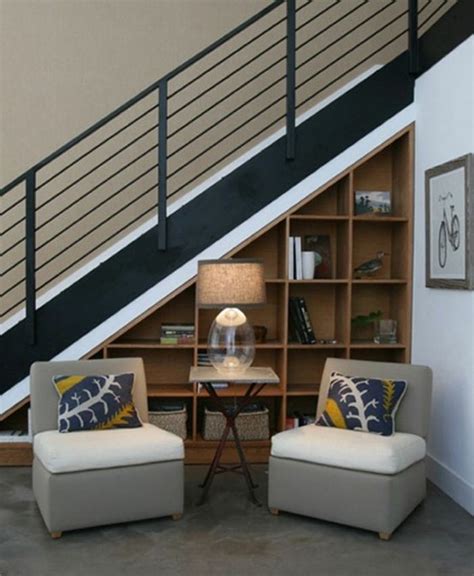 Two Chairs Sitting In Front Of A Book Shelf Under A Stair Case Next To