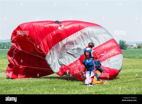 Skydiver With Red Parachute After Landing On The Ground Stock Photo Alamy