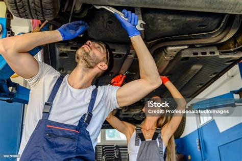 A Female Car Maintenance Worker With Male Coworker Is Fixing The