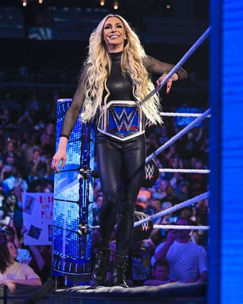 A Woman In A Wrestling Outfit Standing On Top Of A Platform