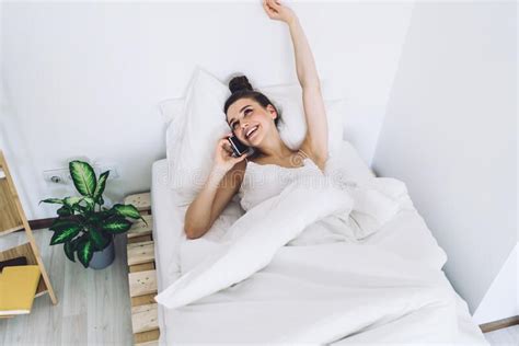 Delighted Brunette Chilling On Bed And Chatting On Cellphone Stock Image Image Of Blanket