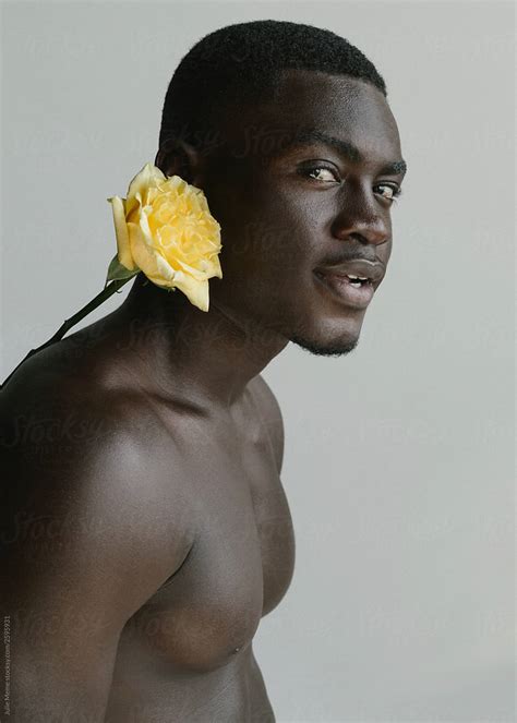 Charming Young Man With A Yellow Rose Behind His Ear By Stocksy