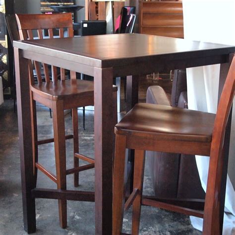 Two Wooden Stools Sitting Next To Each Other In Front Of A Table And Chairs