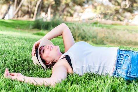 Premium Photo Beautiful Woman Resting On The Grass In A Park