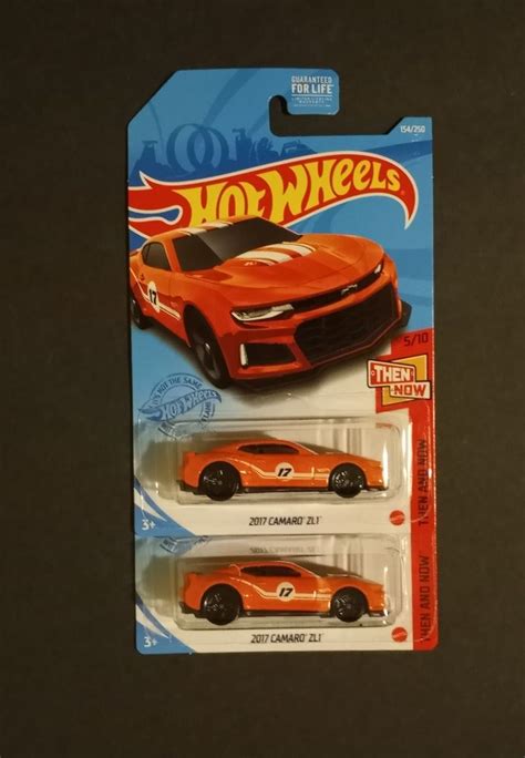 Two Hot Wheels Cars Are Shown In The Package One Is Orange And The