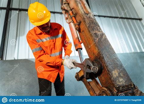 A Technician Working Excavator Repair With Large Iron Wrench In A Hand