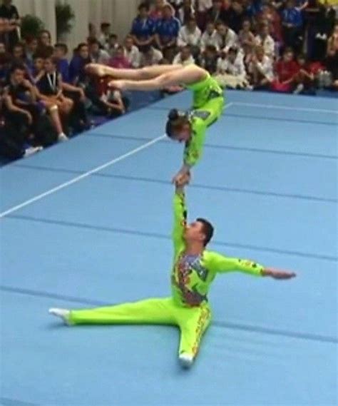 Two Acrobatic Dancers Performing On A Blue Floor In Front Of An Audience