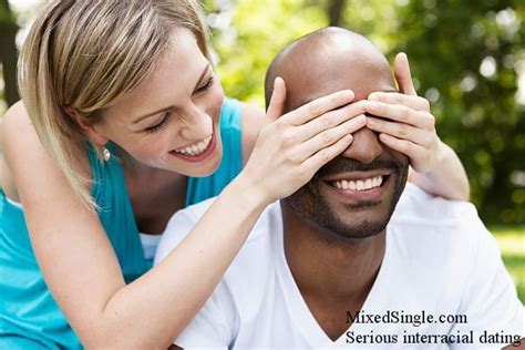 a man and woman are smiling while holding each other s hands over their eyes