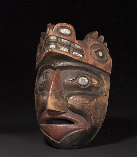 A Nootka Mask Carved With Broadly Defined Facial Features The Recessed Eyes Inset With Abalone