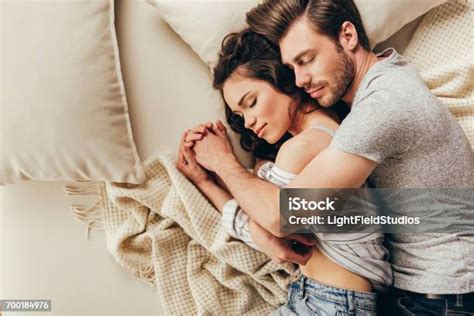 ベッドで寝ながらハグ美しい幸せな若いカップルの平面図 抱きしめるのストックフォトや画像を多数ご用意 抱きしめる カップル ベッド