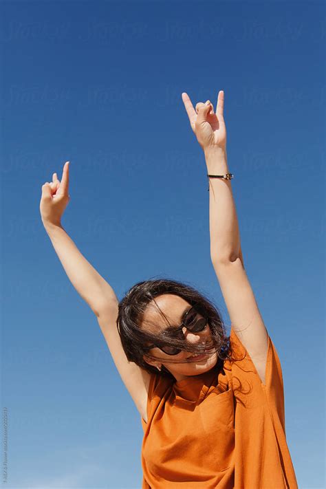 Smiling Young Asian Woman Showing Horns Gesture By Stocksy Contributor Danil Nevsky Stocksy