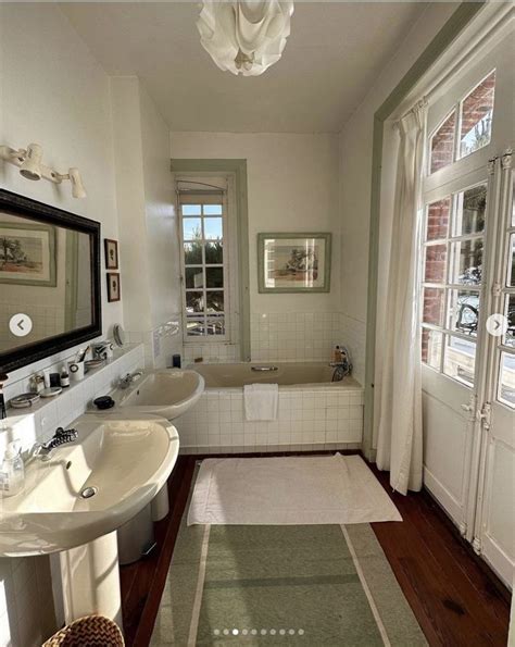 A Bathroom With Two Sinks And A Bathtub Next To A Window In The Room