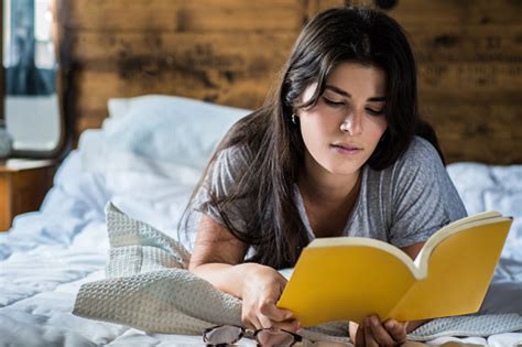 Woman Laying In Bed And Reading Book Stock Photo Download Image Now