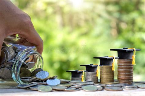 Graduation Cap On A Stack Of Coins That Runs Out Of A Money Jar Stock