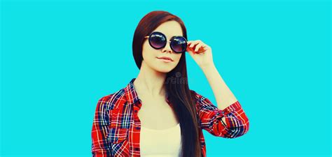 Portrait Of Beautiful Young Brunette Woman Wearing Sunglasses On Blue Background Stock Image