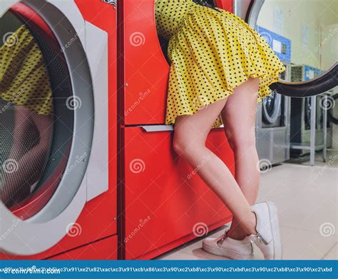 Woman In The Bathroom Putting Head Into Washing Machine Stock Image