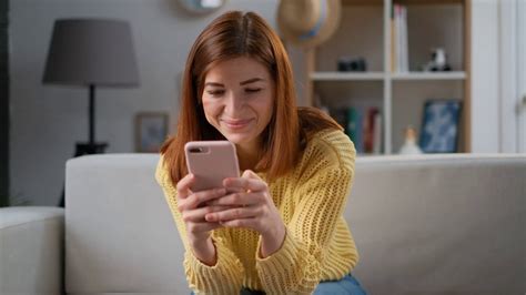 Young Successful Woman Using Smartphone App At Home Living Room Home