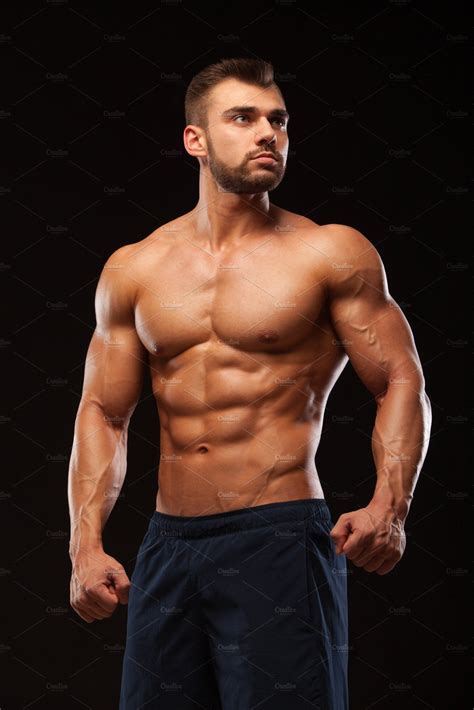 fitness muscular man is posing and showing his torso with six pack abs muscular men male